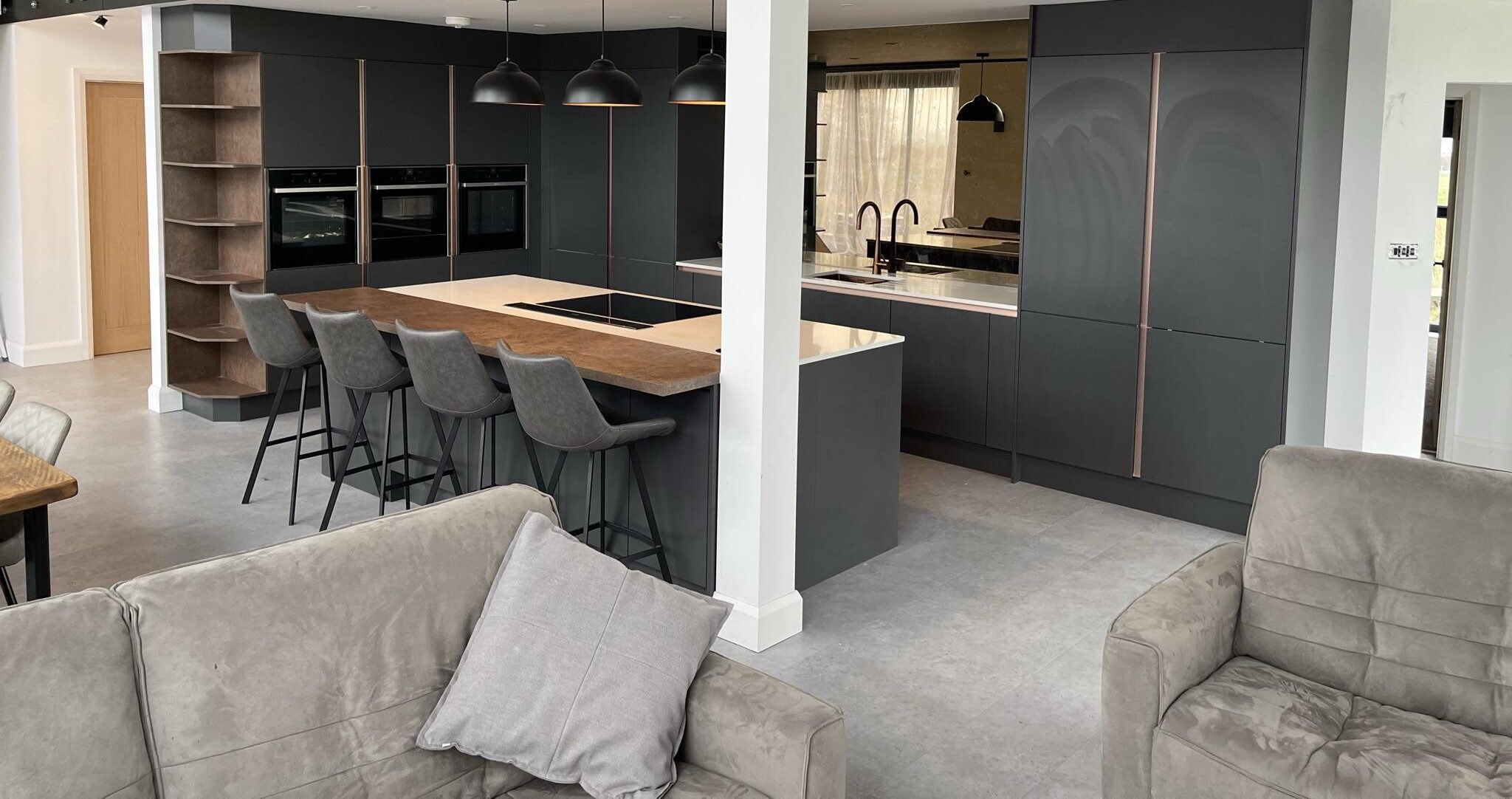 Large open-plan kitchen with modern design and black-and-wood finishes